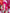 A cosplayer with bright pink hair, red glasses, and strawberry-themed outfit holds a red intimate toy in a pink/red strawberry-themed photoshoot setup.