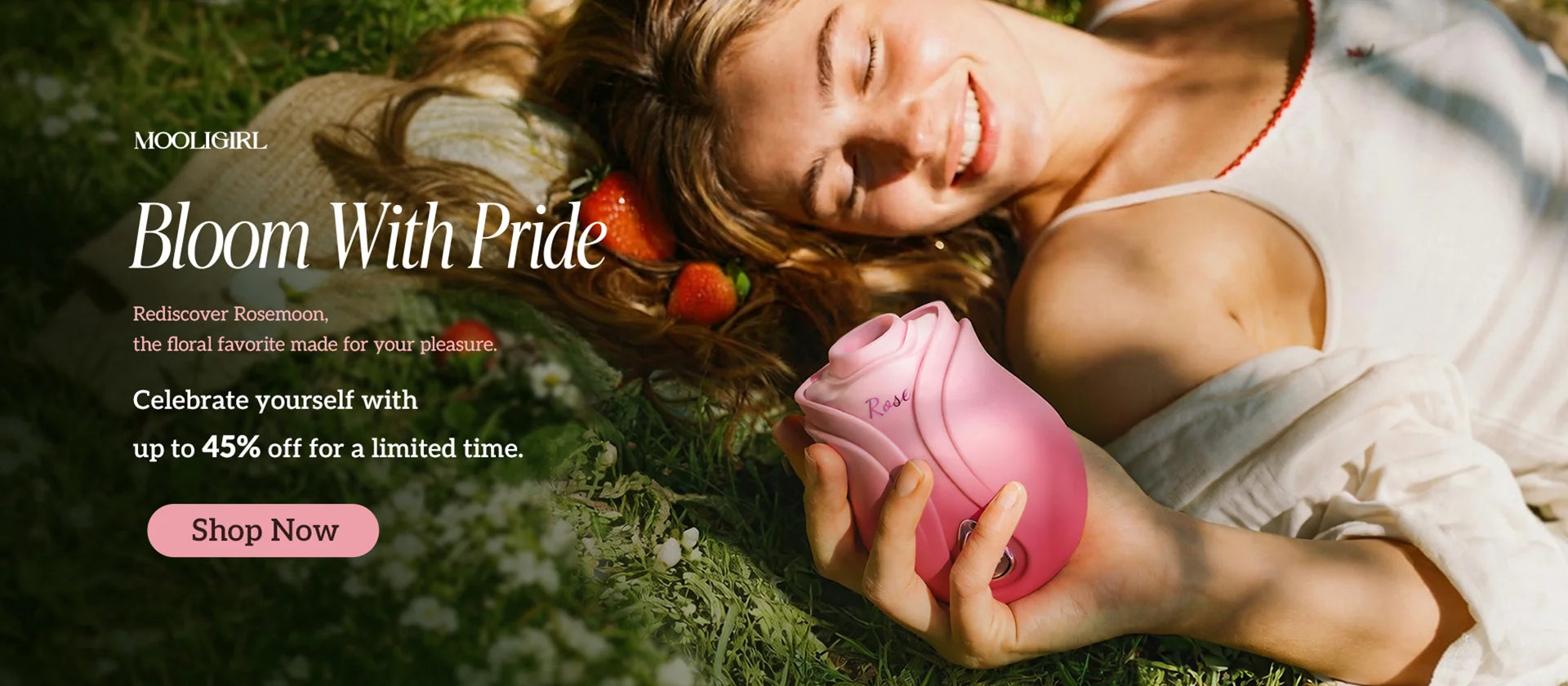 MOOLIGIRL Pride Month Rosemoon rose toy horizontal promotional banner, outdoor lawn scene, woman lying on flowers holding pink rose intimate toy, headline "Bloom With Pride", product intro text with limited time up to 45% off, light pink "Shop Now" CTA button at bottom left